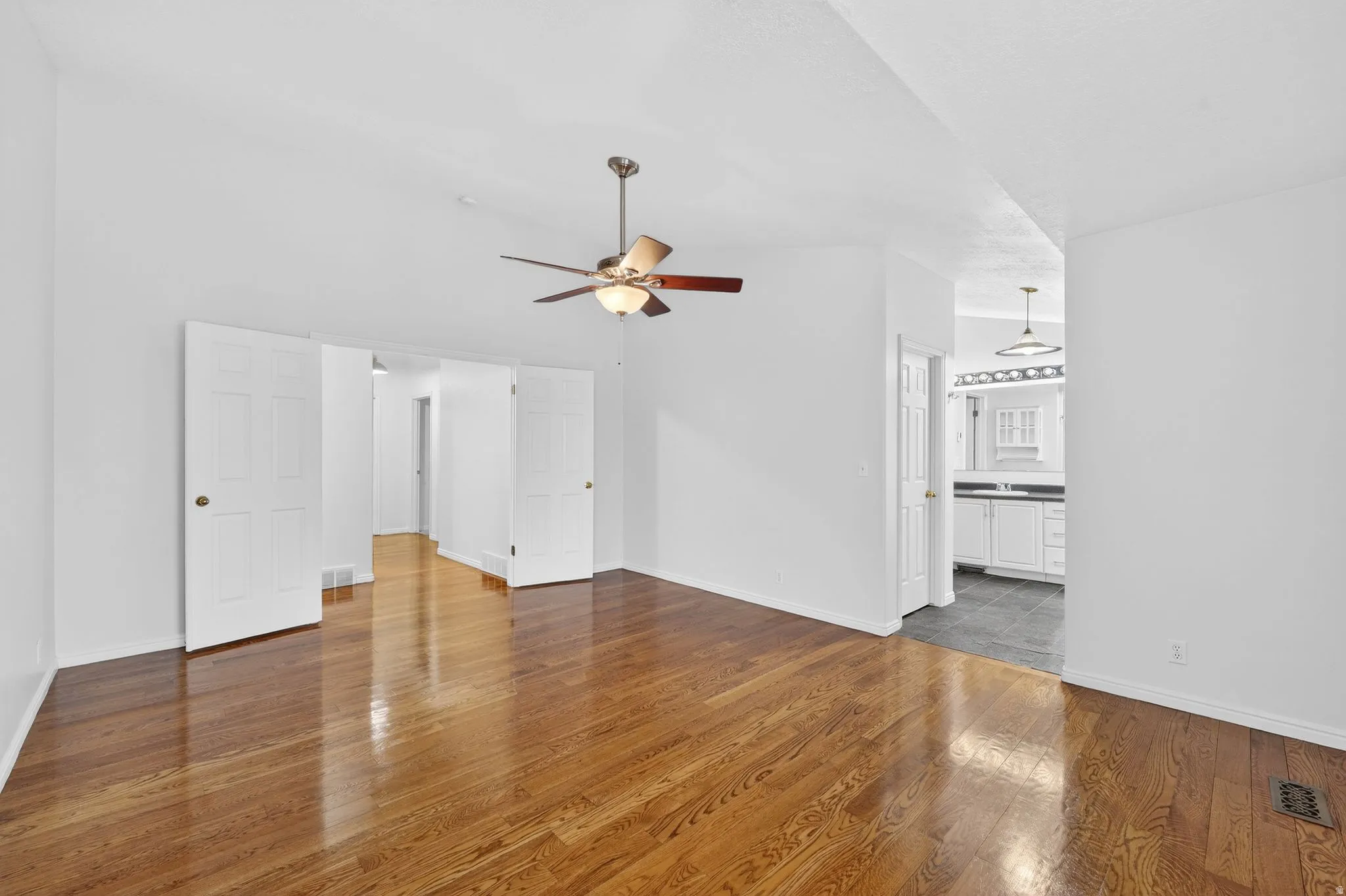 Unfurnished living room featuring dark wood finished floors and ceiling fan