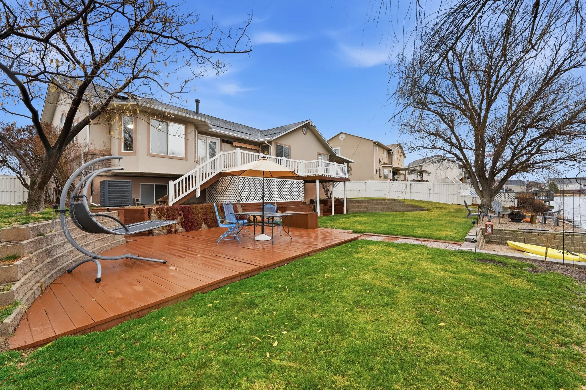 Back of house featuring a deck, a fenced backyard, stucco siding, and a patio area