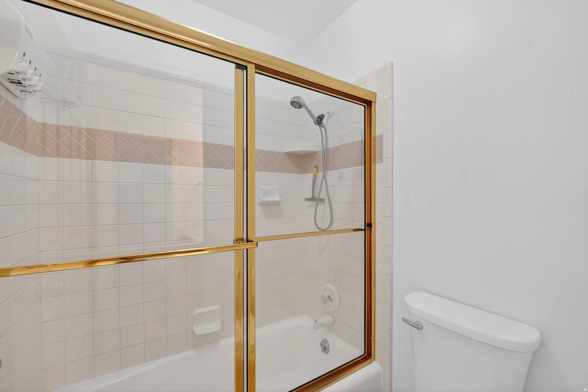 Full bath with toilet and bath / shower combo with glass door