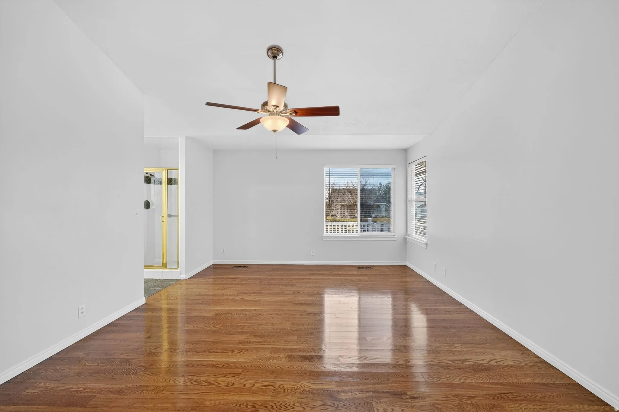Empty room featuring dark wood-style floors and ceiling fan