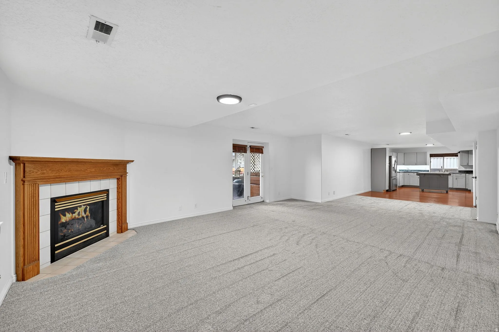 Unfurnished living room with light colored carpet and a fireplace