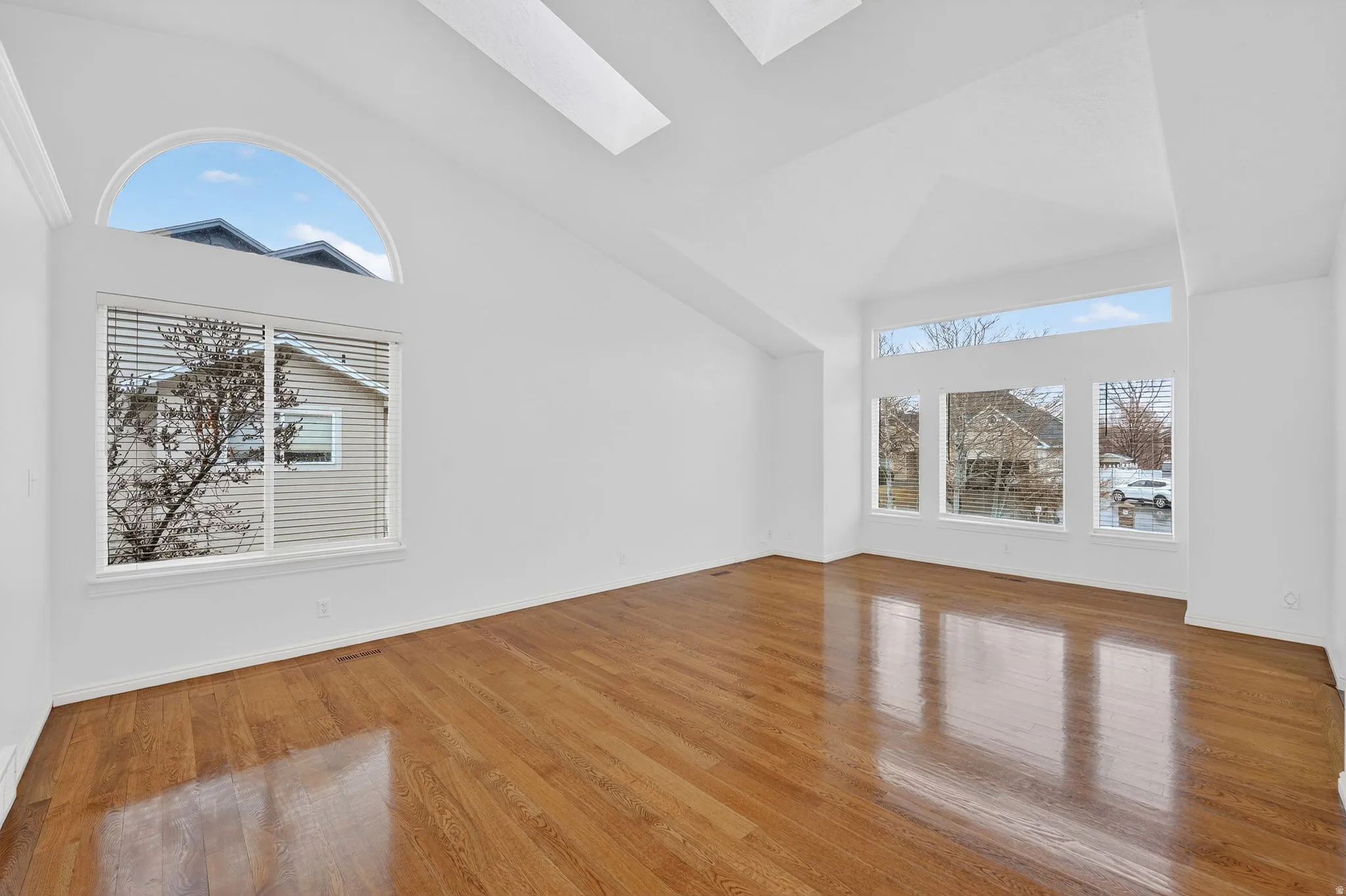 Additional living space with a skylight, lofted ceiling, and light wood-style flooring