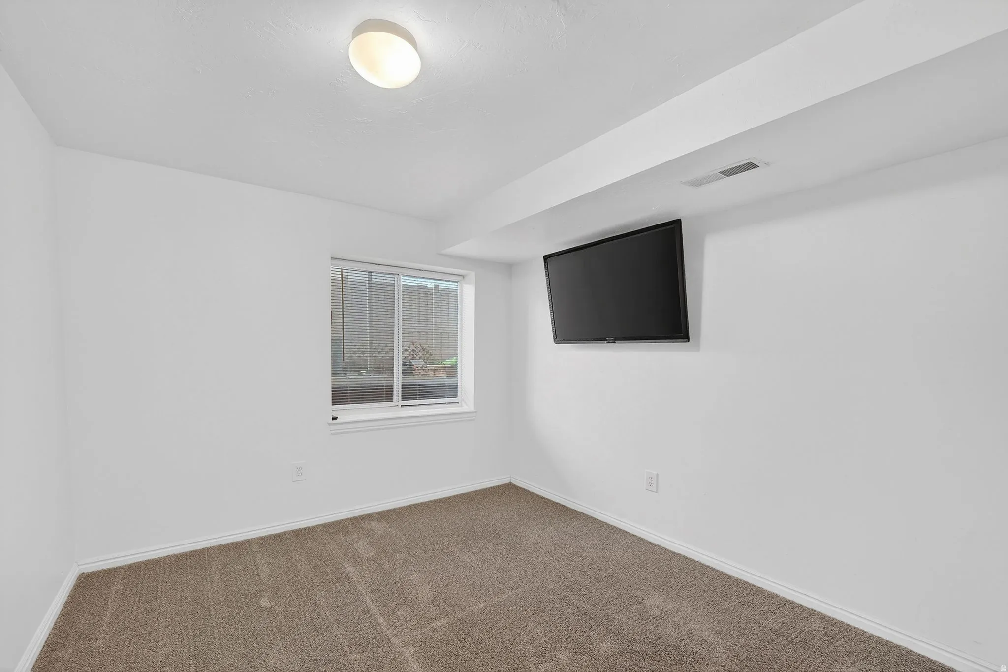 Spare room featuring baseboards and dark colored carpet