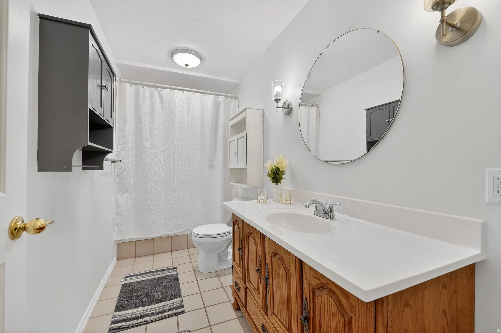 Bathroom featuring vanity, curtained shower, and light tile patterned floors