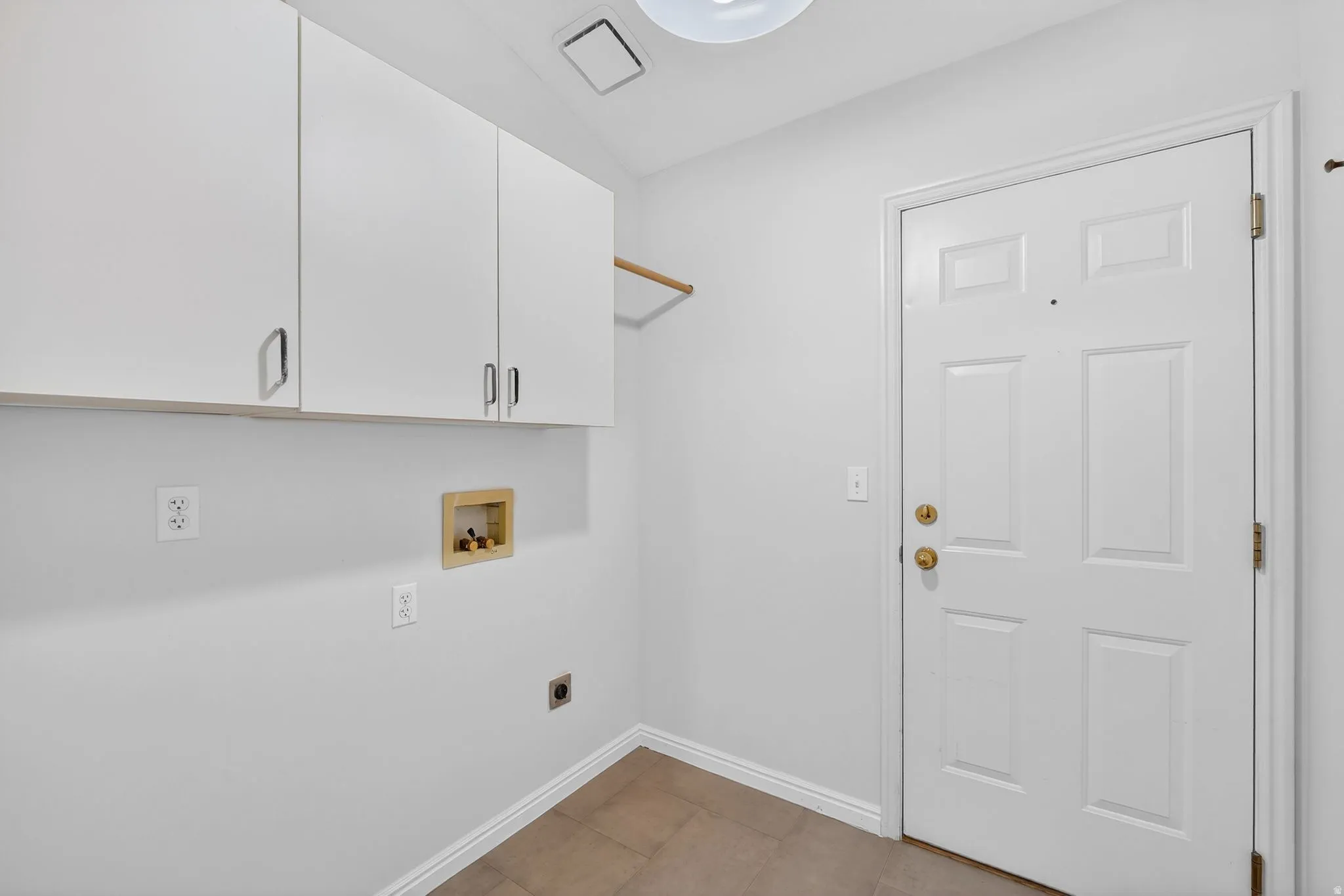 Laundry room featuring hookup for a washing machine, cabinet space, electric dryer hookup, and light tile patterned flooring