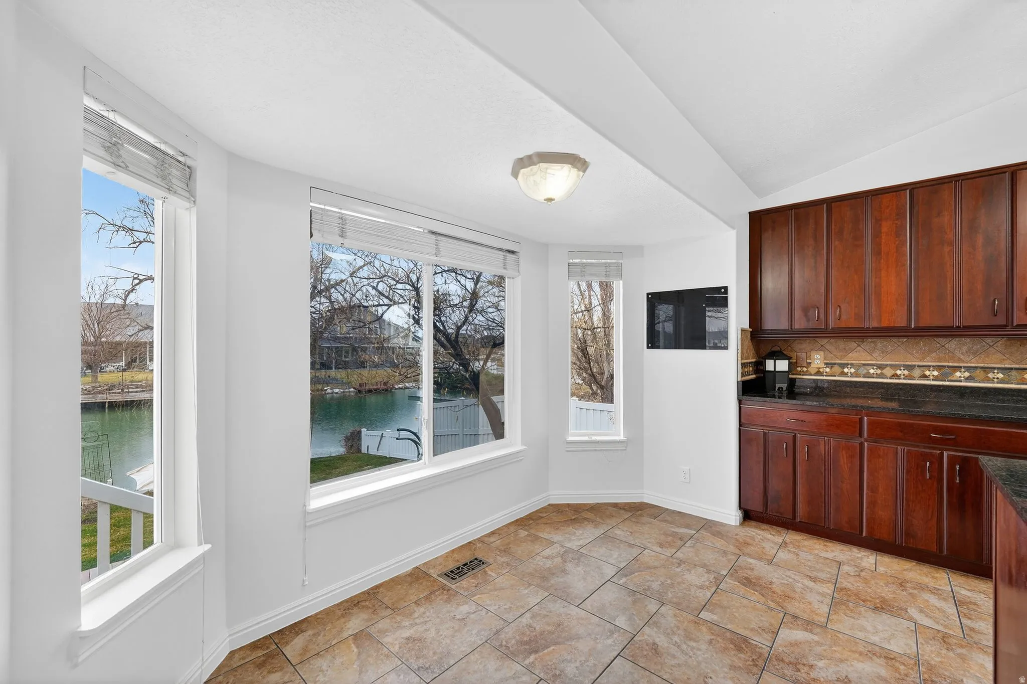 Unfurnished dining area featuring a water view and vaulted ceiling