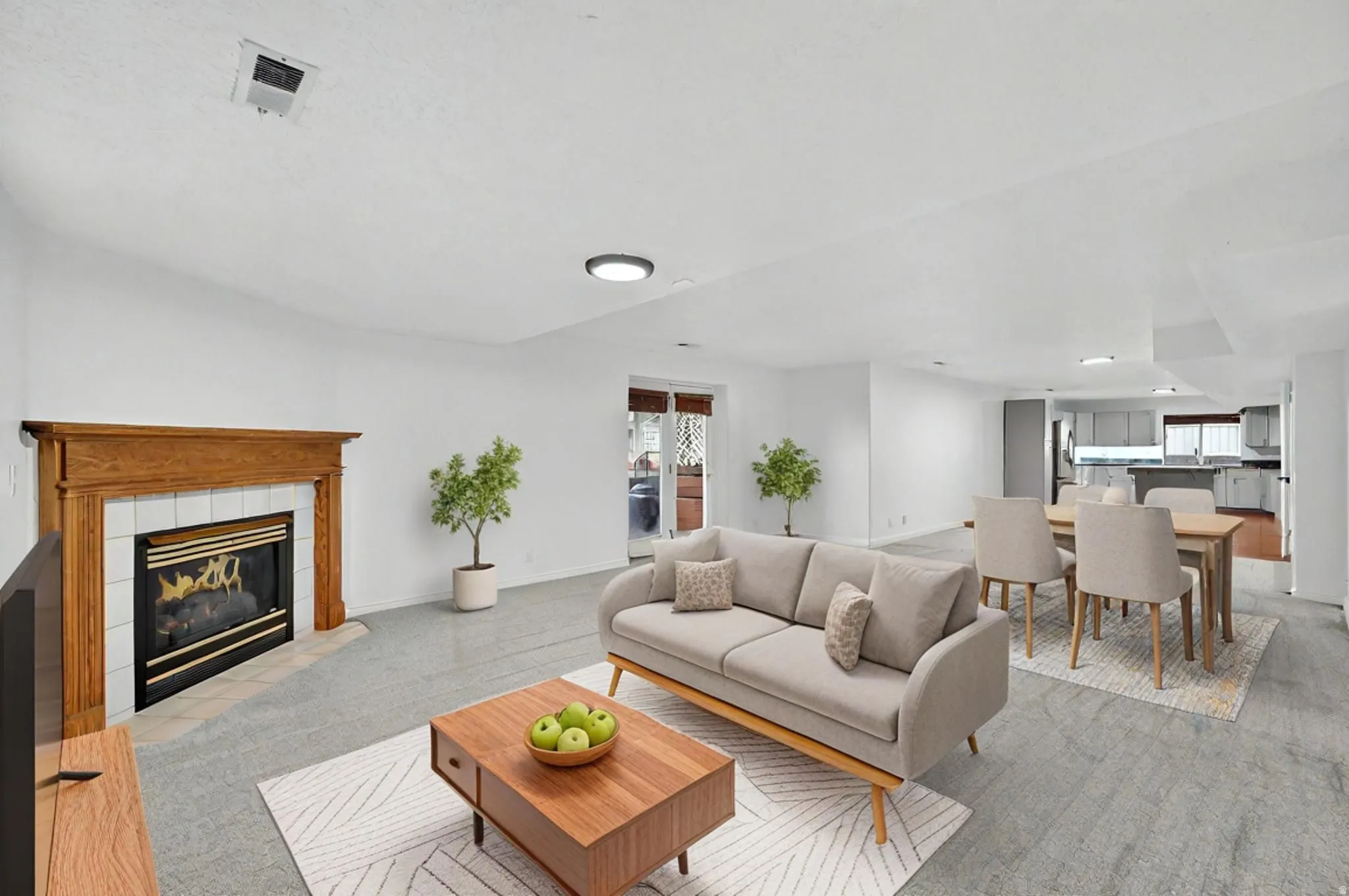 Living area with a tiled fireplace and light carpet