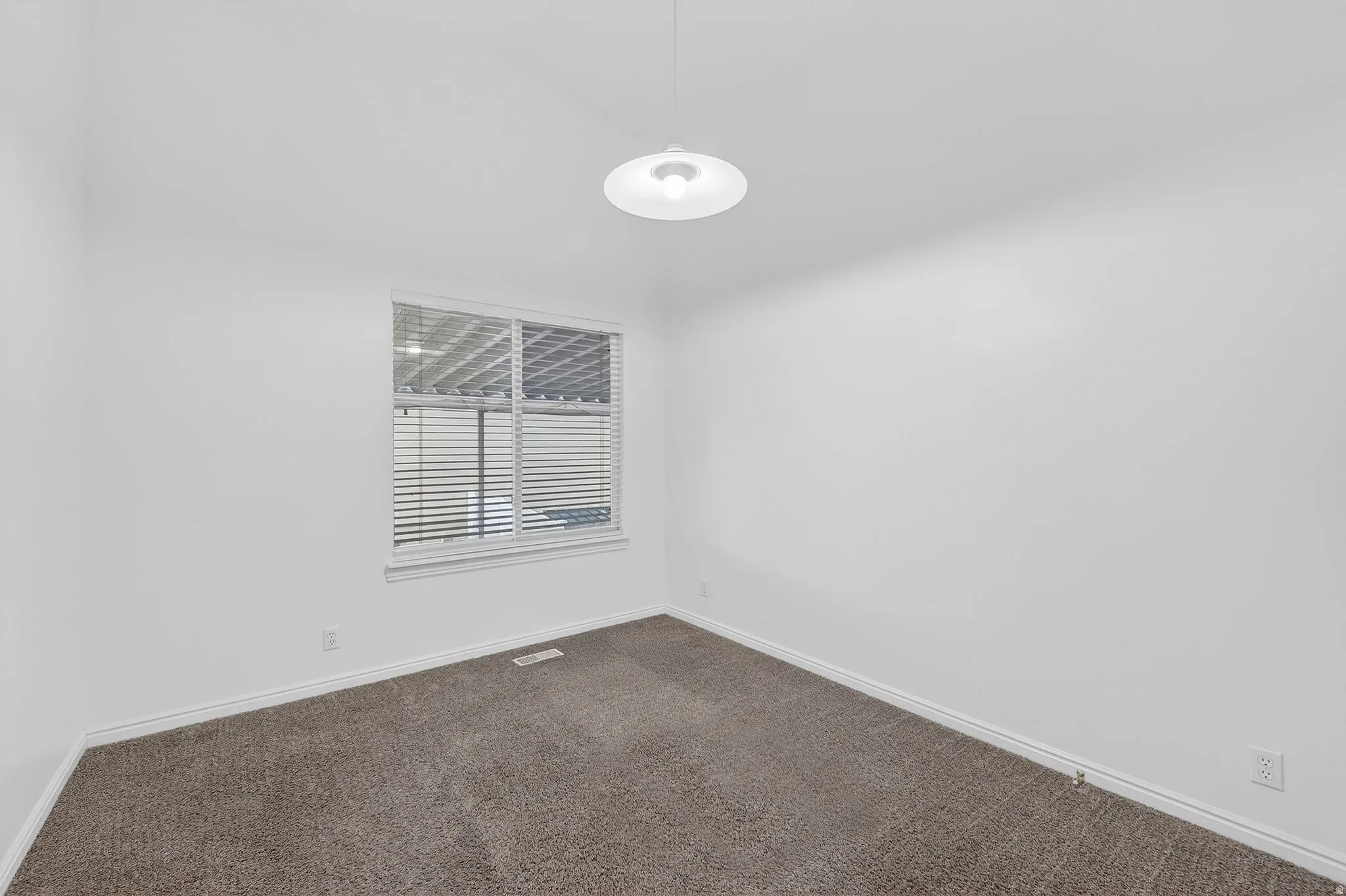 Unfurnished room featuring dark carpet and baseboards