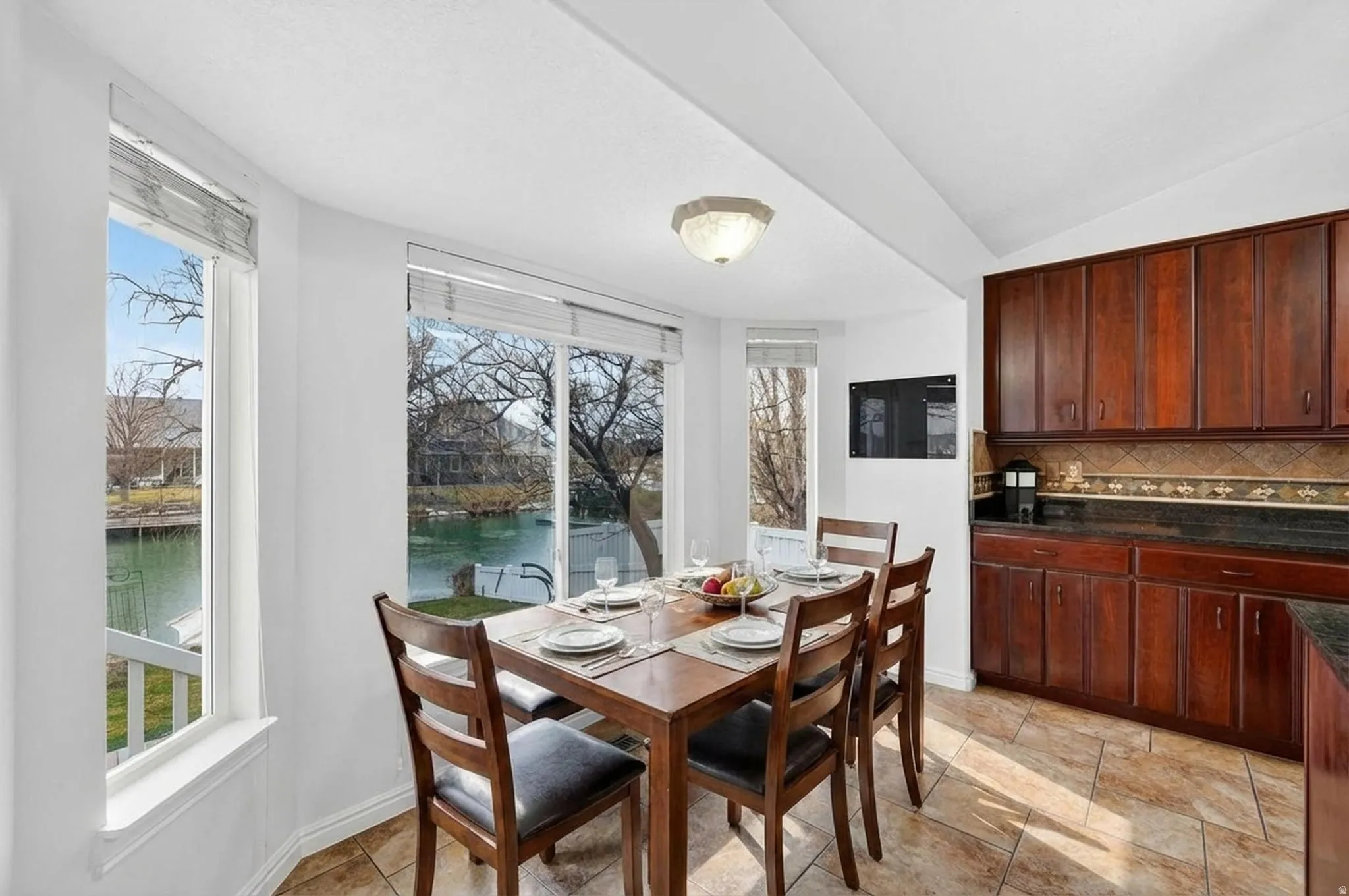 Dining room with a water view and lofted ceiling