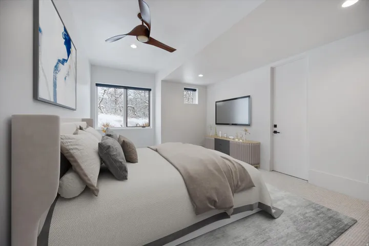 Carpeted bedroom with a ceiling fan and recessed lighting