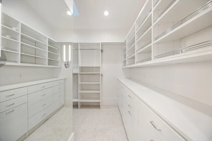 Walk in closet with light colored carpet