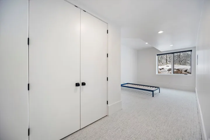 Unfurnished bedroom featuring light carpet, recessed lighting, and a closet