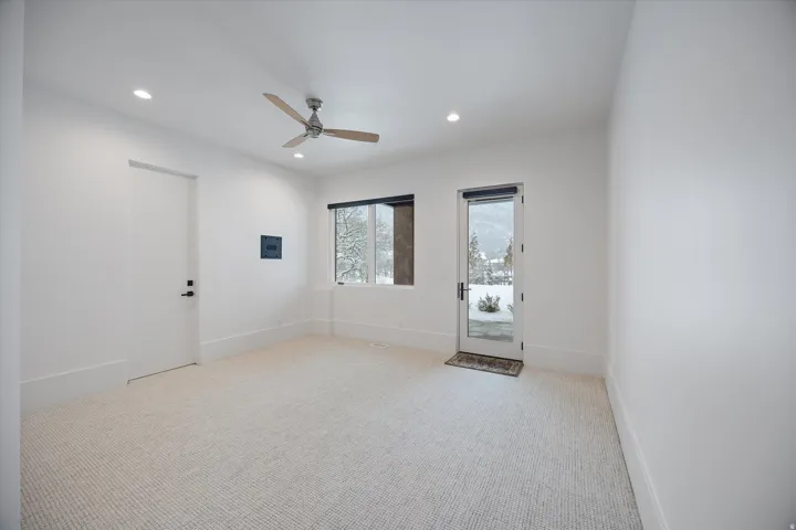 Empty room featuring light colored carpet, a ceiling fan, and recessed lighting
