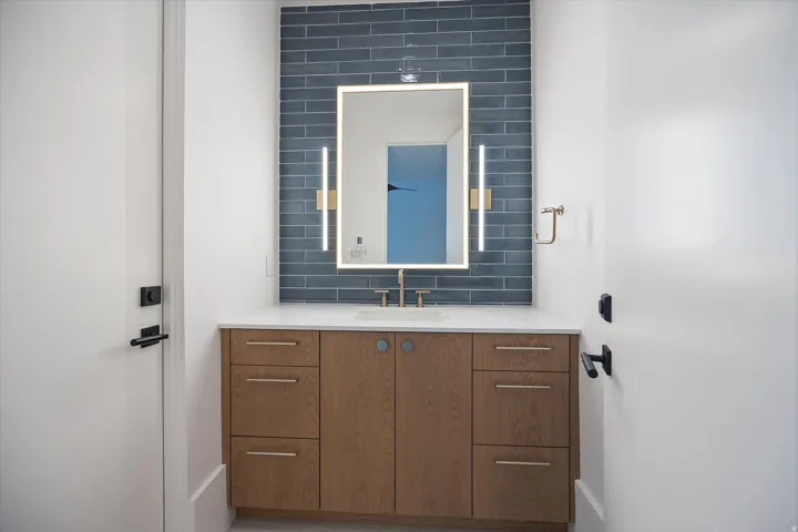 Bathroom featuring vanity and decorative backsplash