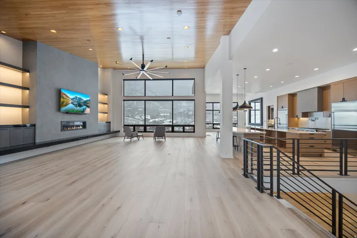 Living area featuring light wood-style flooring, a large fireplace, recessed lighting, and a high wood ceiling