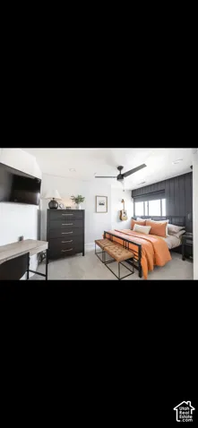 Wall-mounted television, built-in ceiling fan, textured accent wall, and wall-to-wall carpeting