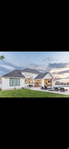Rear view of house with a patio, a yard, and a pool