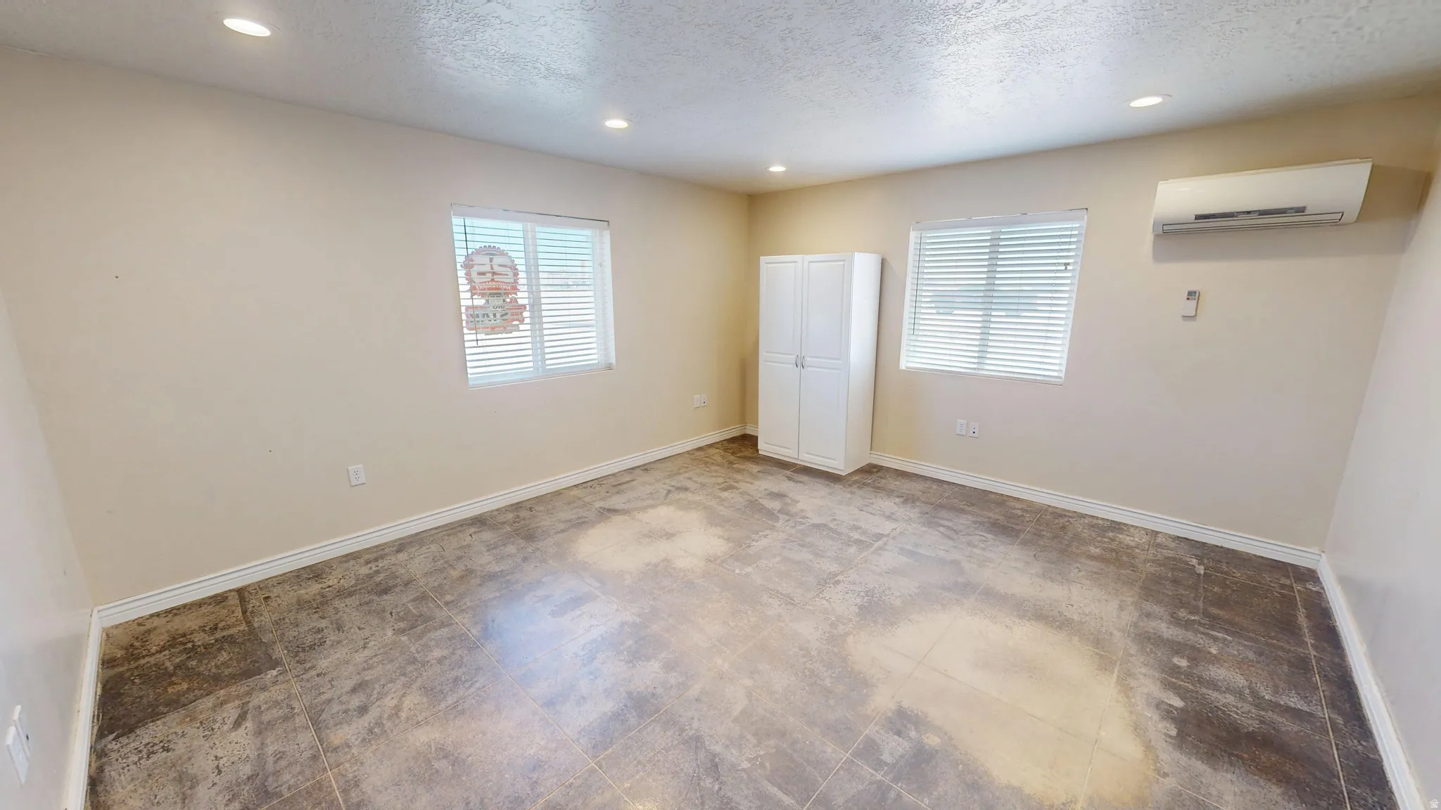 Unfurnished bedroom featuring recessed lighting, multiple windows, and a textured ceiling