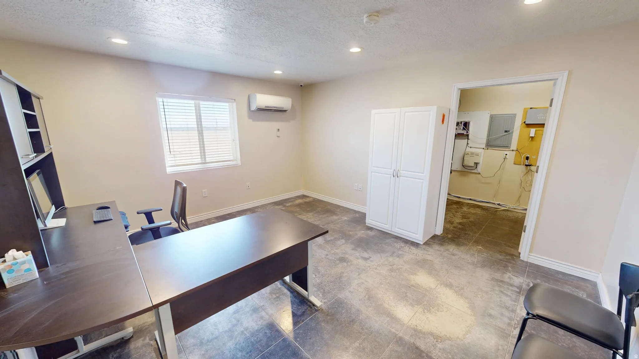 Office area featuring a textured ceiling and recessed lighting