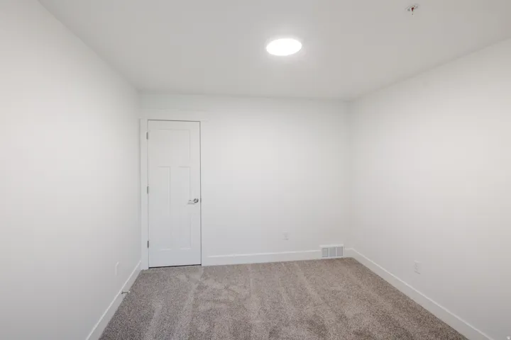 Neutral wall finishes with a single interior door featuring a satin nickel knob
