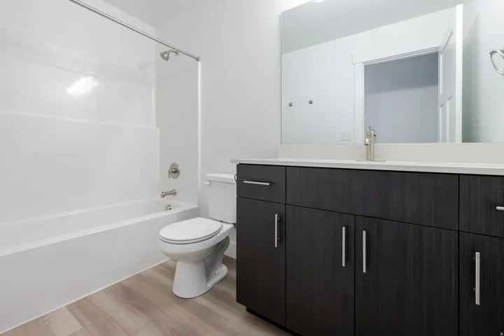 Bathroom featuring a dark wood-finish vanity with a light countertop, integrated sink, and brushed nickel faucet