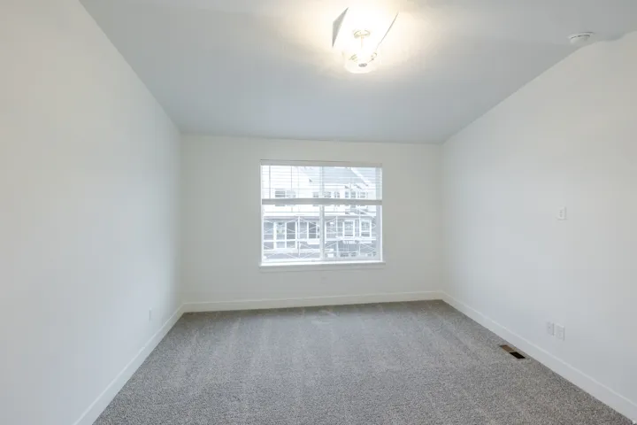 Room featuring neutral wall paint and gray carpet flooring