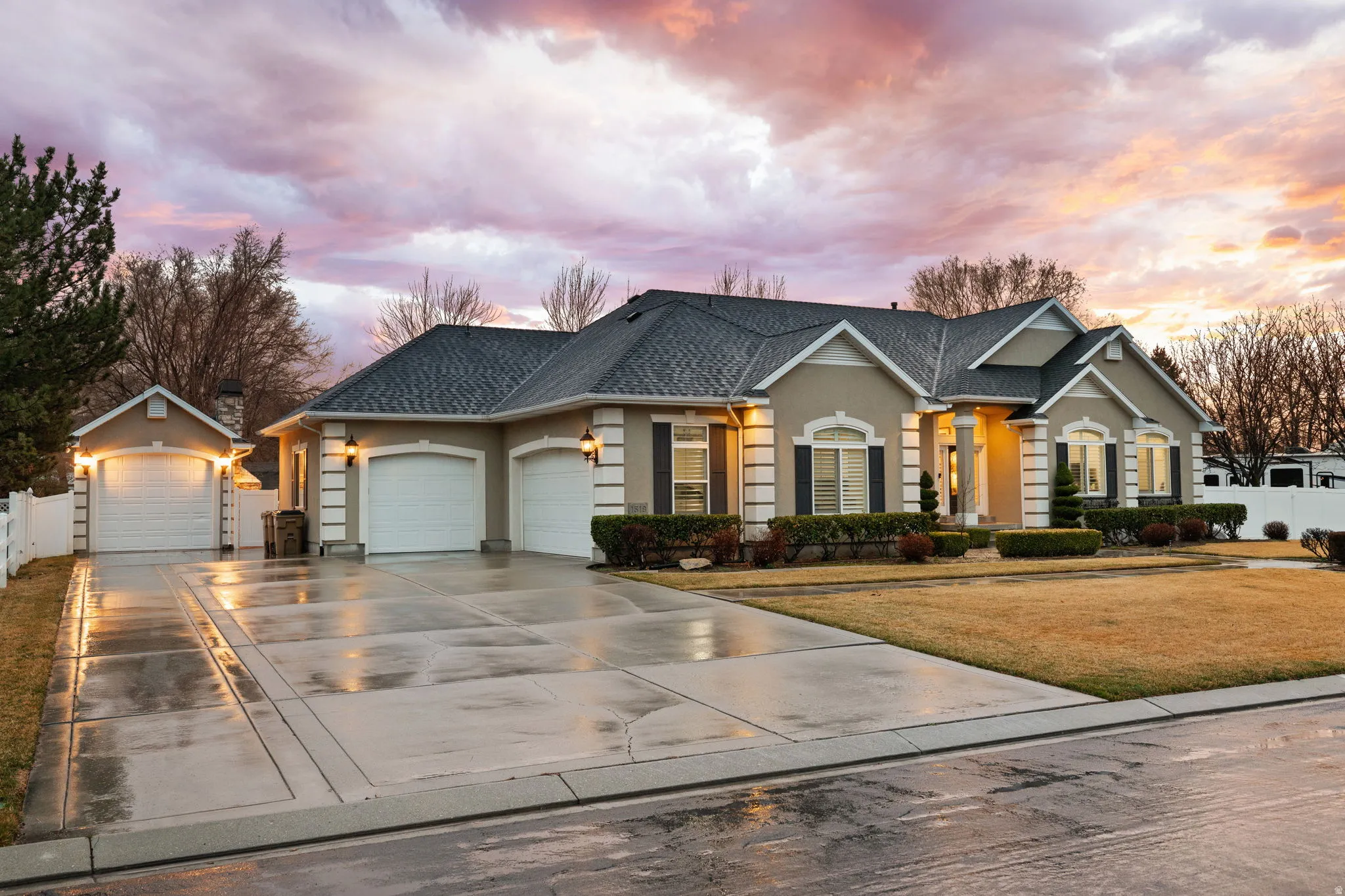 View of front facade featuring stucco siding, a garage, driveway, and a shingled roof