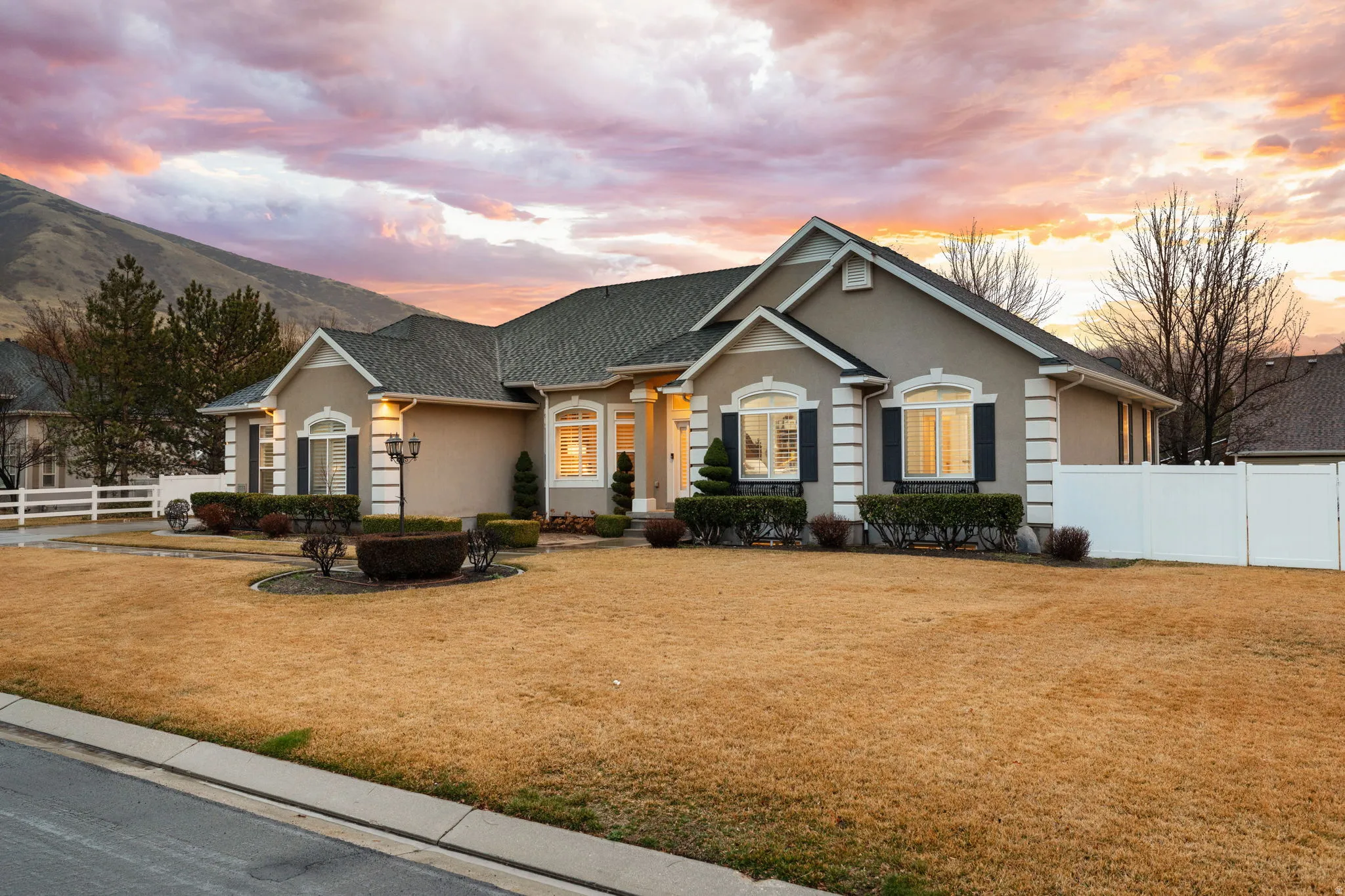 View of front facade featuring stucco siding and roof with shingles