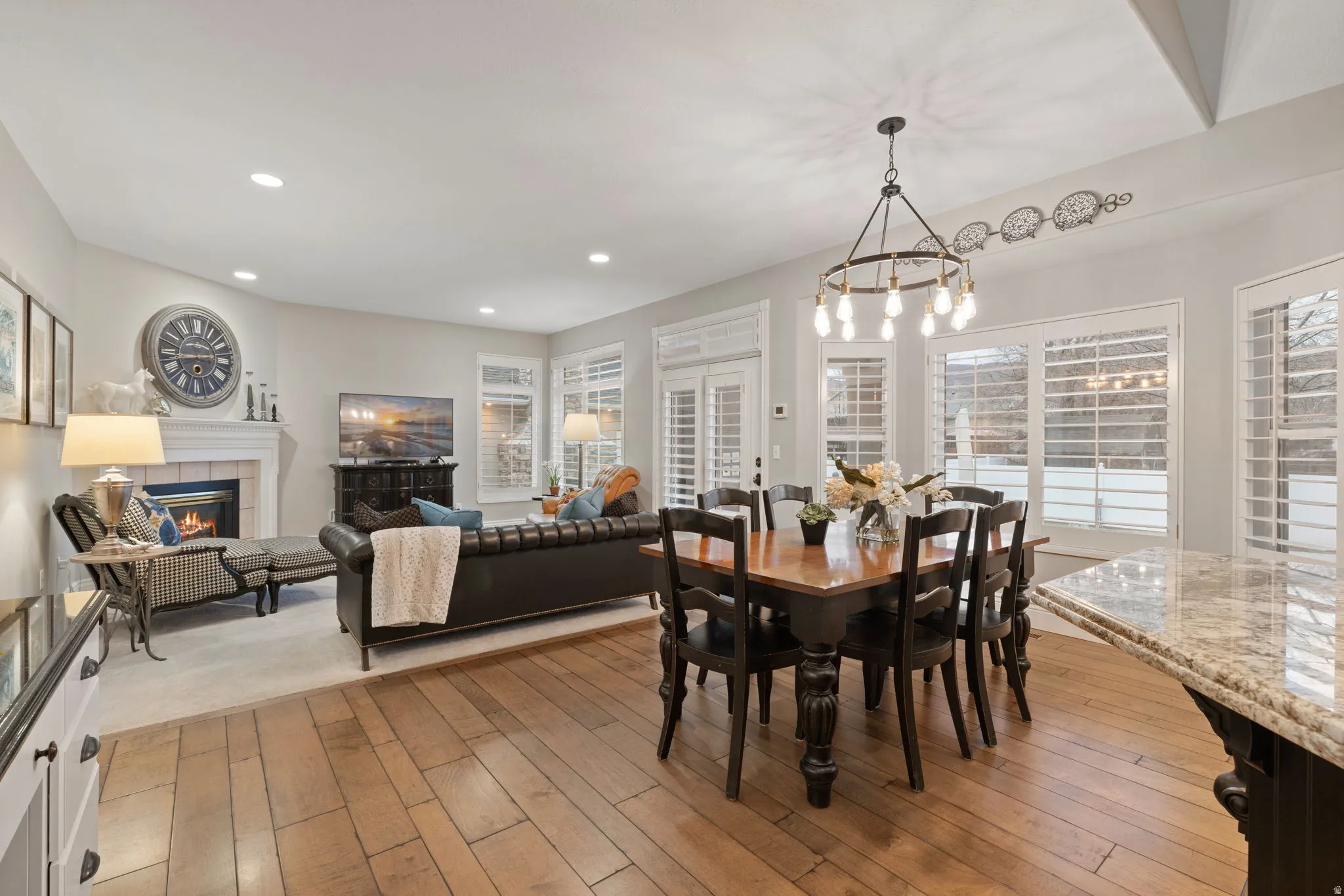 Dining space with a fireplace, light wood-style flooring, plenty of natural light, and a chandelier