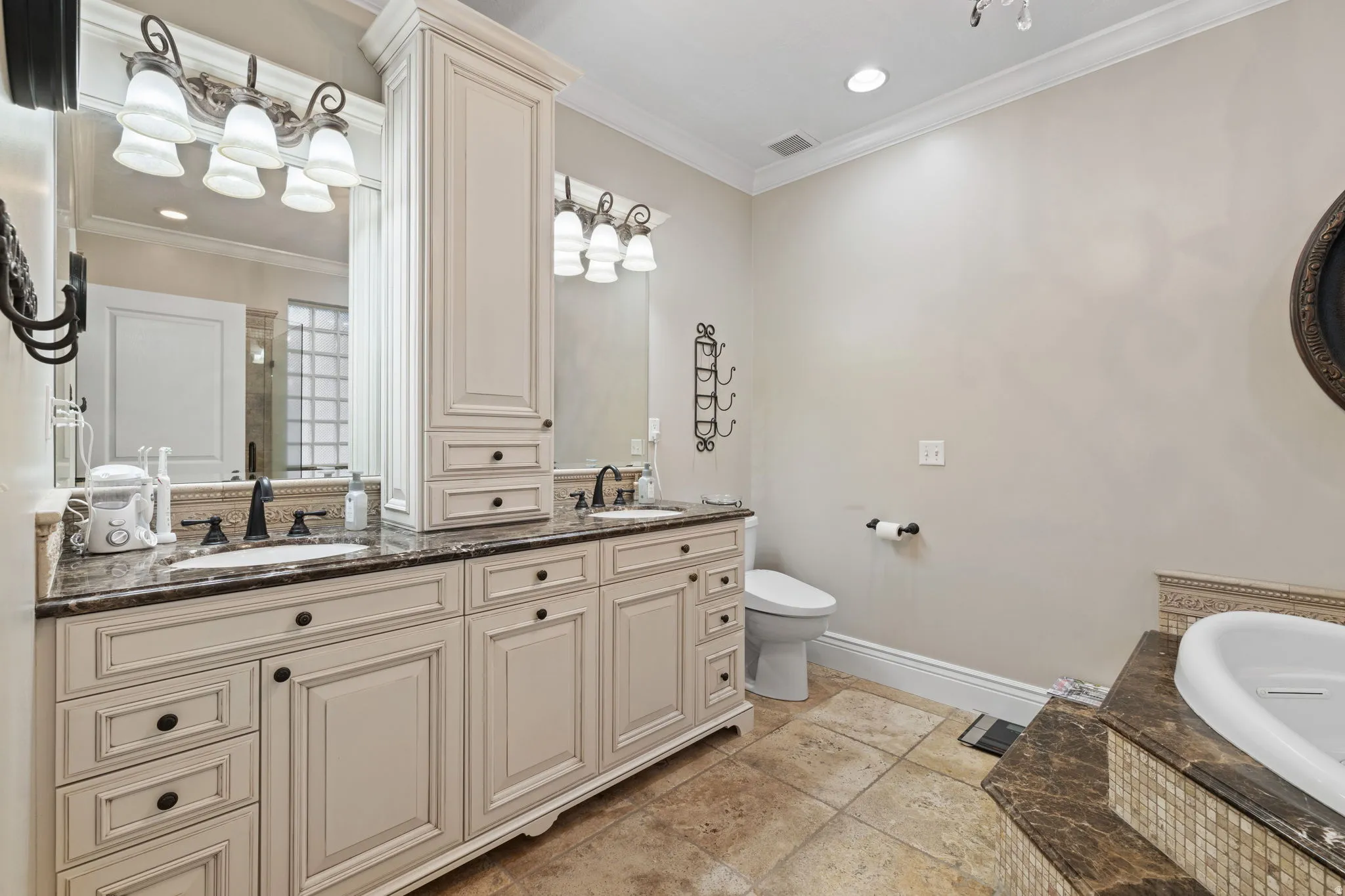 Bathroom featuring double vanity, crown molding, a bath, and recessed lighting