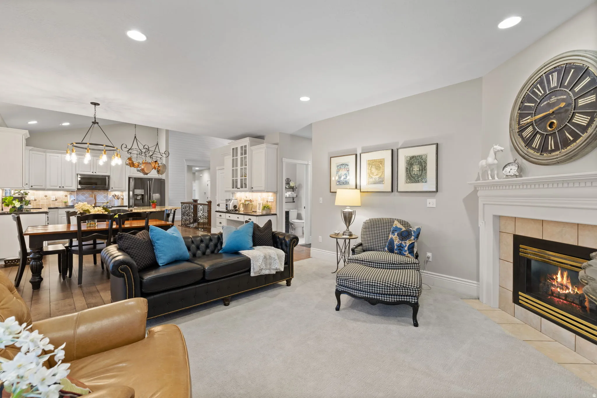 Living area featuring a tiled fireplace, a chandelier, and light colored carpet