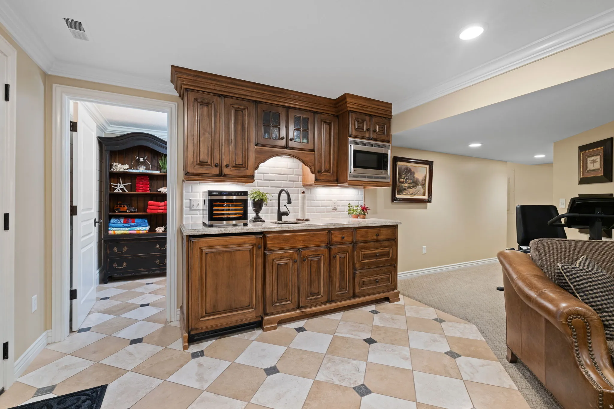 Bar featuring crown molding, glass insert cabinets, recessed lighting, light stone countertops, and stainless steel microwave