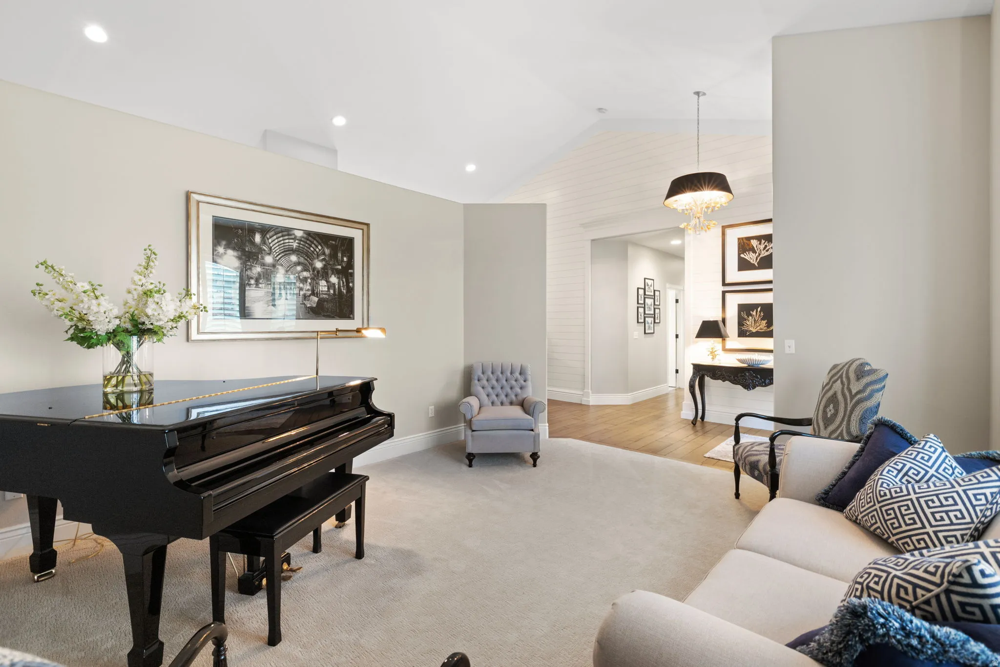 Living room featuring light colored carpet and a chandelier