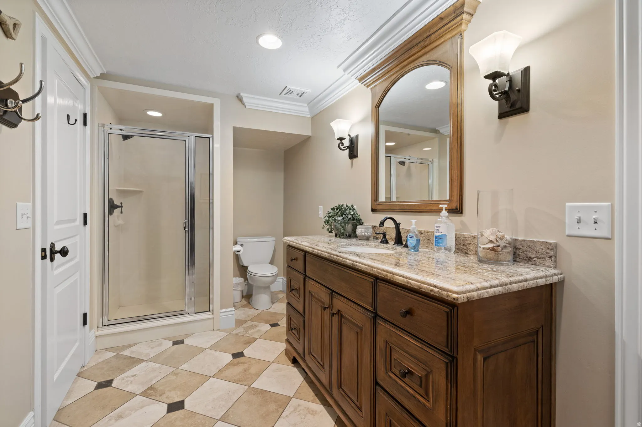 Bathroom with a shower stall, vanity, ornamental molding, and recessed lighting