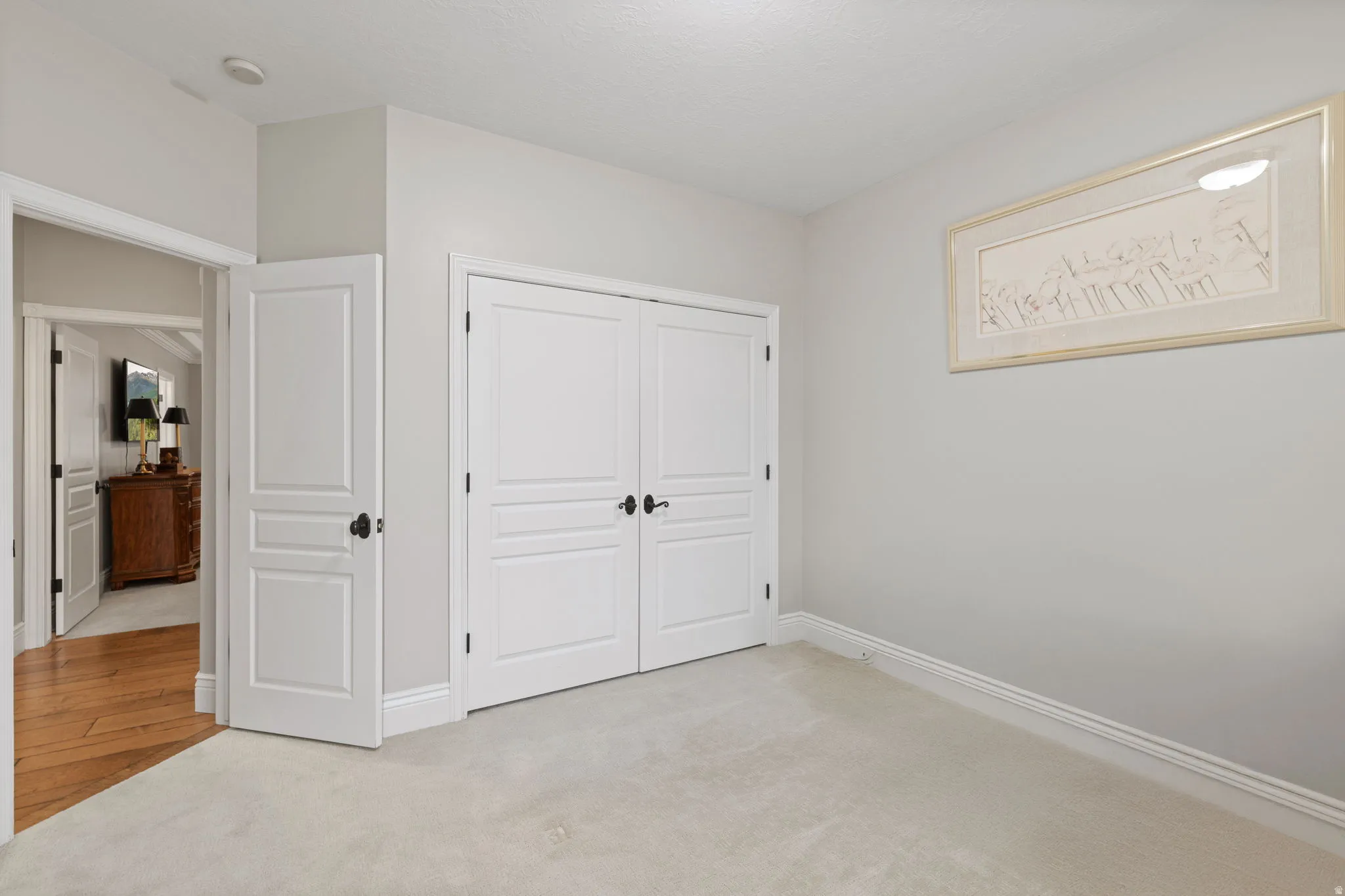 Unfurnished bedroom with light carpet and a closet