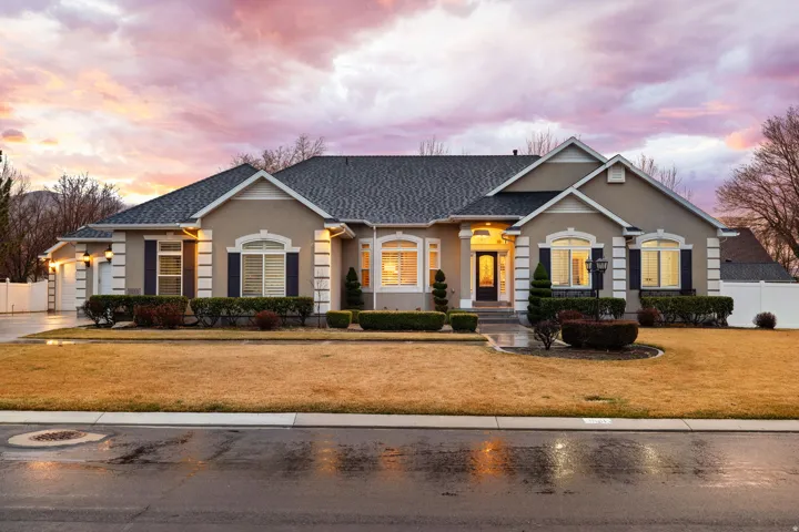 View of front of home featuring stucco siding, a garage, concrete driveway, and a shingled roof