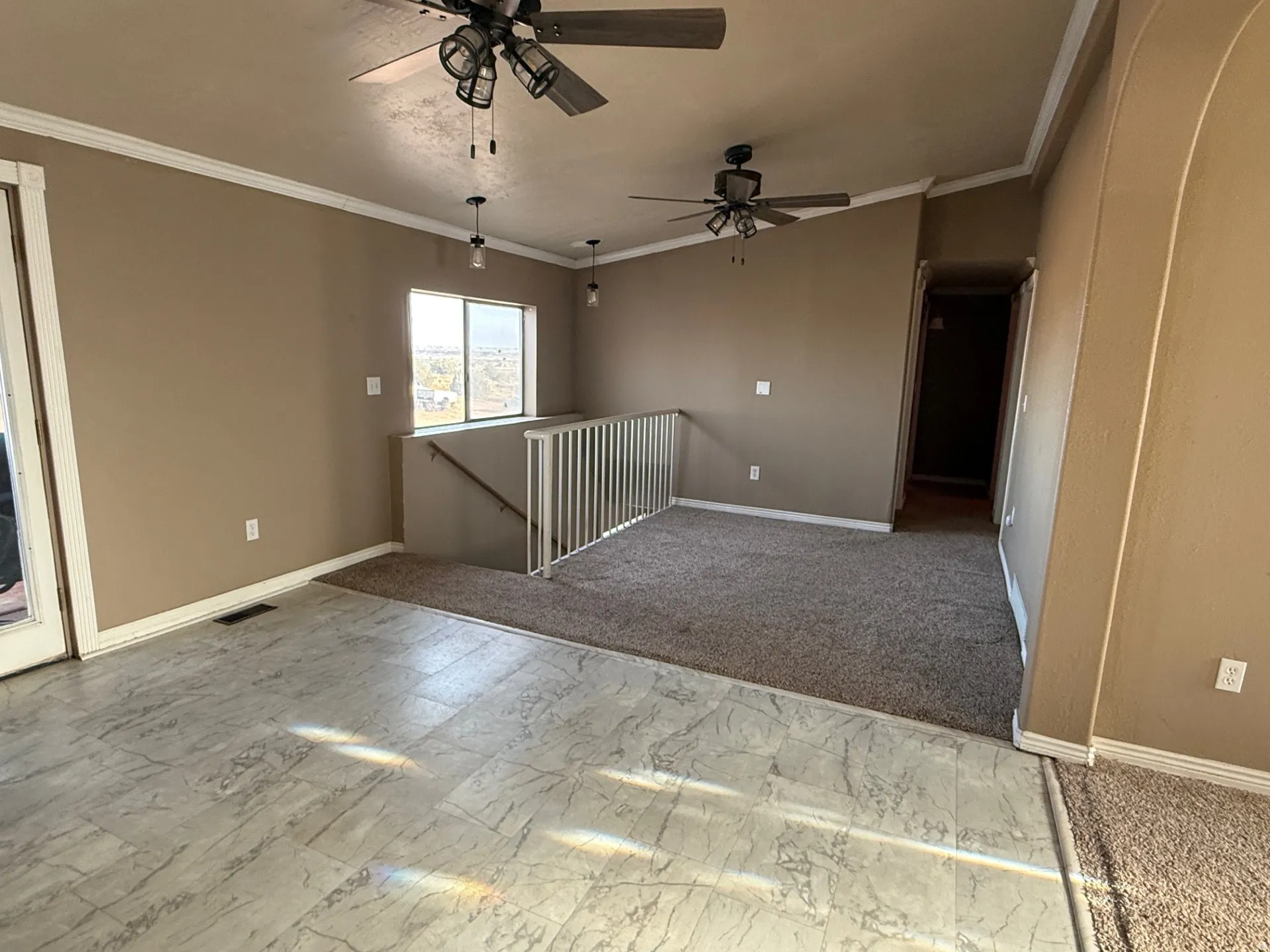 Empty room with crown molding, a ceiling fan, and light colored carpet