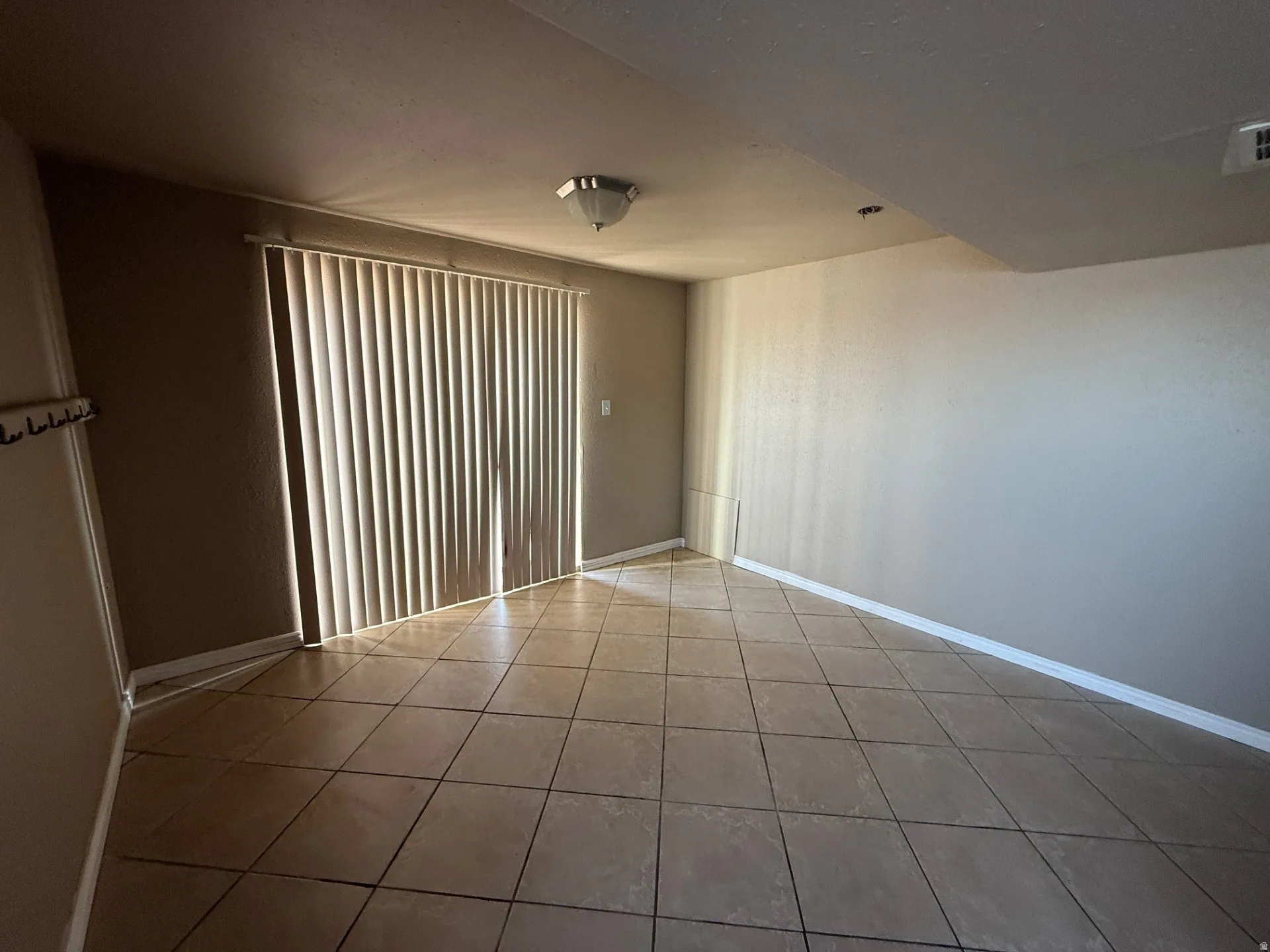 Spare room with baseboards and light tile patterned flooring