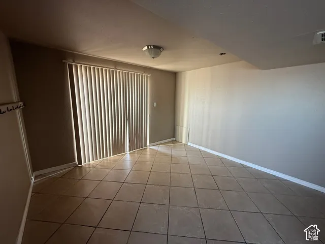 Spare room with baseboards and light tile patterned flooring