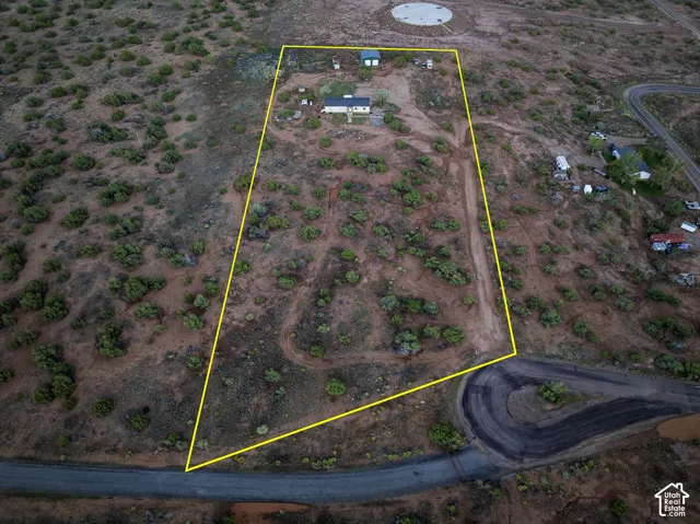 Expansive undeveloped land with a single-story dwelling and two accessory structures