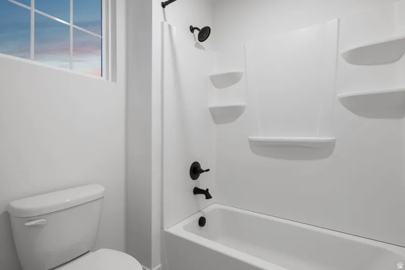 Full bath featuring toilet and shower / bath combo