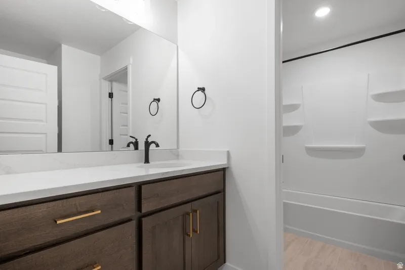 Full bathroom featuring vanity, recessed lighting, and light wood-style floors