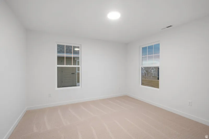 Spare room with baseboards and light carpet