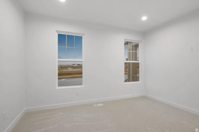 Empty room featuring light colored carpet and recessed lighting