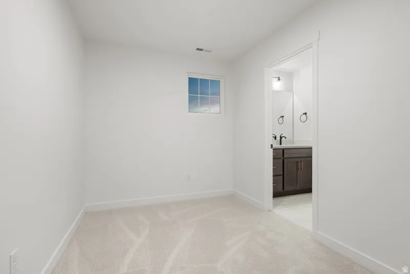 Spare room featuring light carpet and baseboards