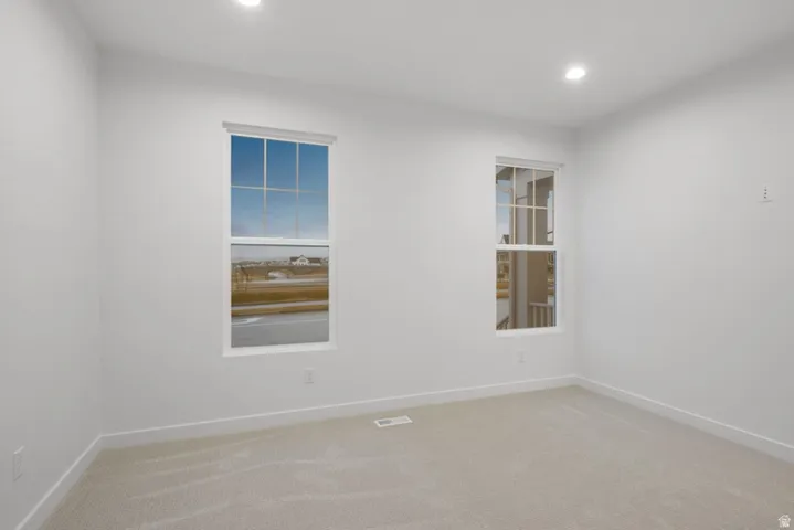 Empty room featuring light colored carpet and recessed lighting
