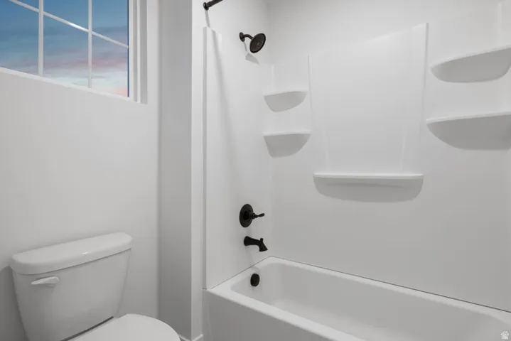 Full bath featuring toilet and shower / bath combo