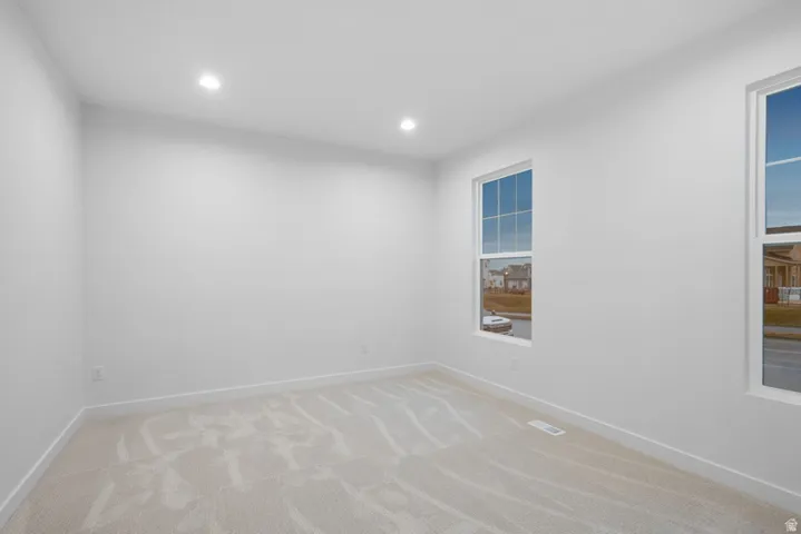 Spare room featuring light colored carpet and recessed lighting