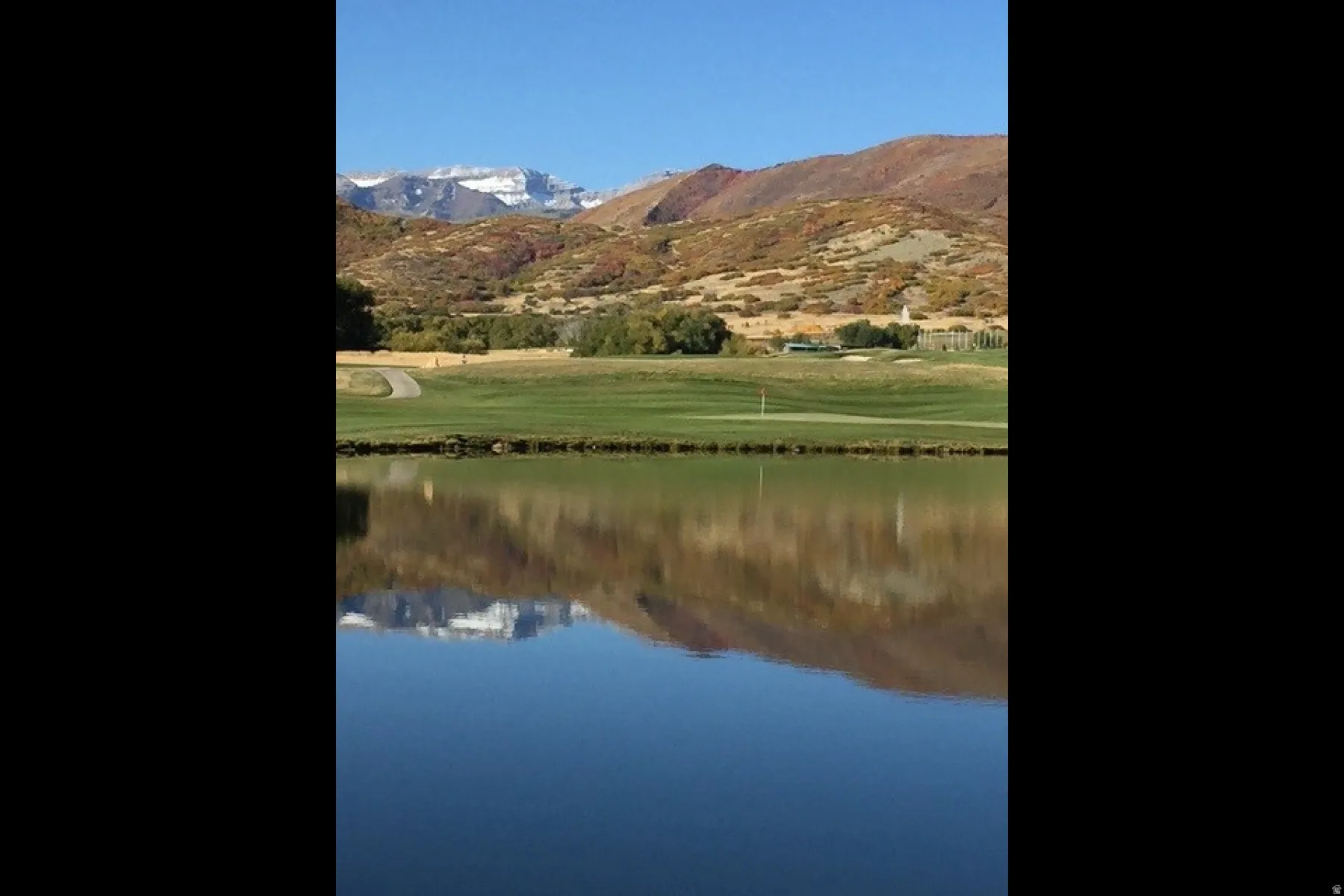 Water view featuring mountains and a golf club