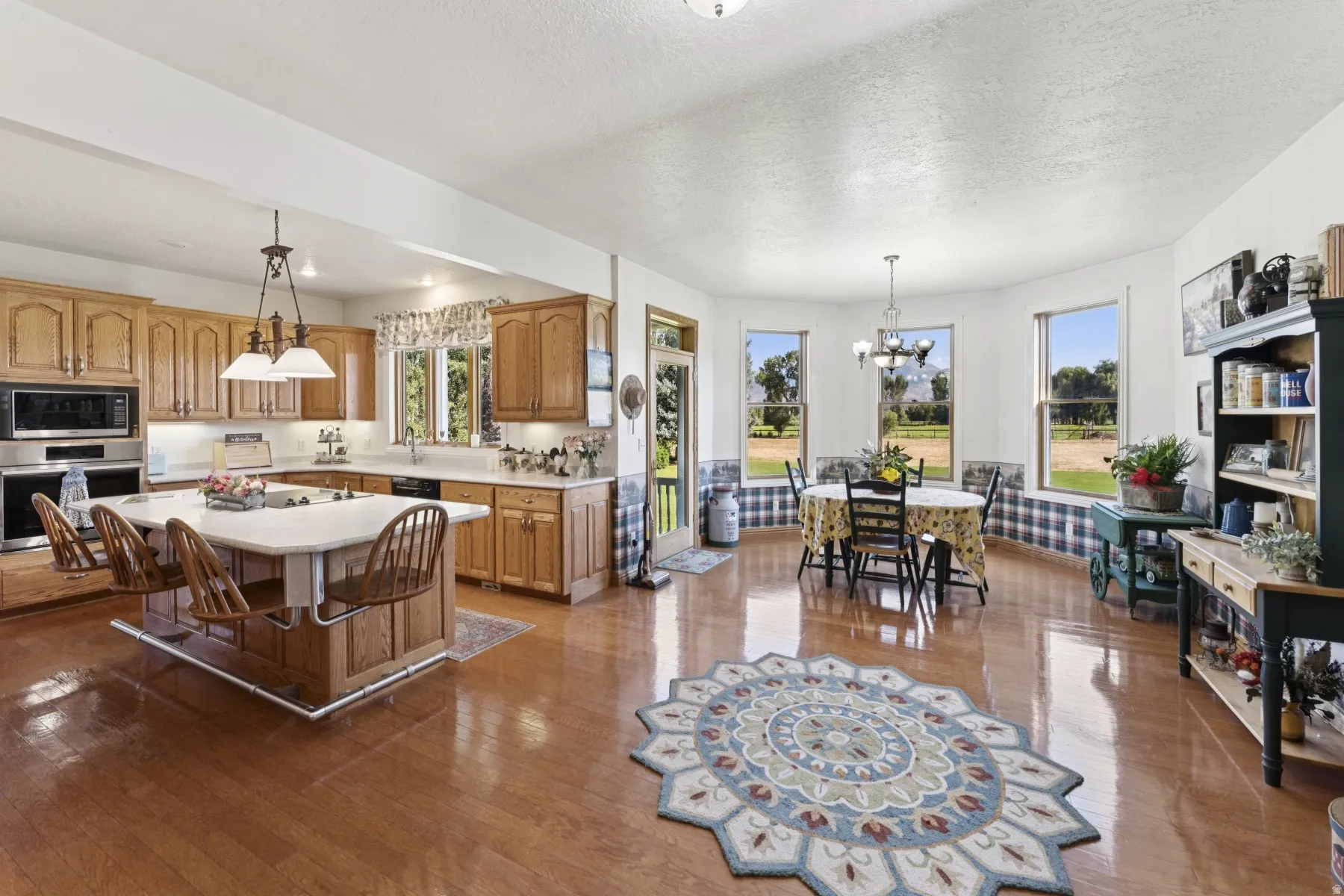 Kitchen featuring light countertops, a kitchen island, stainless steel appliances, a textured ceiling, and a breakfast bar